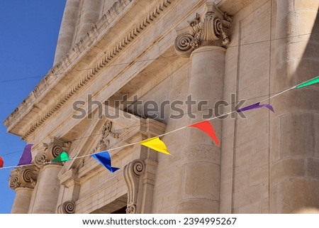 church building, columns, old building, Ionic columns, suspended colorful garlands, blue sky, Locorotondo, Italy