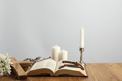 Church Candles, Cross, Rosary Beads, Bible And Willow Branches On Wooden Table Against Light Background. Space For Text