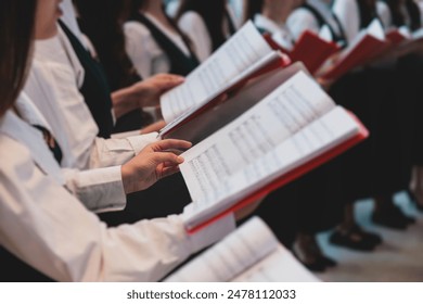 Church choir concert in cathedral, choral artists singing, group of European boys and girls singing in a chorus, students and choristers in white and green uniform performing on stage with conductor - Powered by Shutterstock