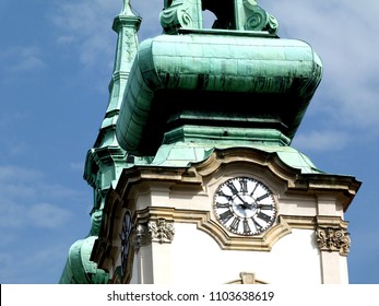 church clock tower with tarnished green copper plated roof and blue sky. weathered patina green color roof. white face round wall clock with black hands and roman numerals. baroque architectural style - Powered by Shutterstock