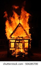 Church with cross burns in flames at dark night. It is a tradition in Spain at San Juan festival.