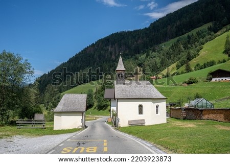 A church divided in two by a road. The location is in Trentino, Italy.