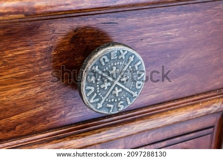Church door knob on a brown wooden door.