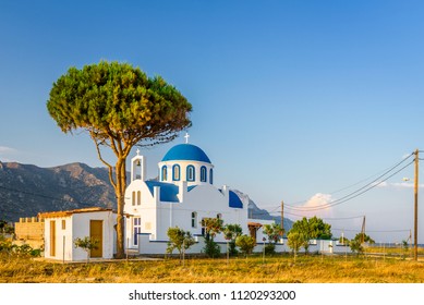 Church, Greece, Kos Island: cozy little blue white church chapel in traditional colors which perched on the greek sea next to a small tree over the barren mountains with a great warm sunset