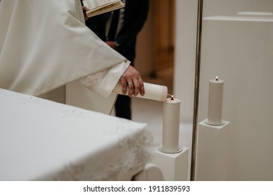 A Church Minister Lighting A Candle From Another Candle During A Ceremony