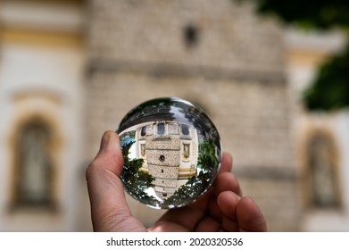 Church St Alban in Matrei in Osttirol through a glass sphere held in a hand, rainy day in summer - Powered by Shutterstock