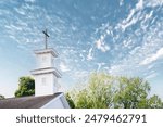 A church with steeple and cross in foreground