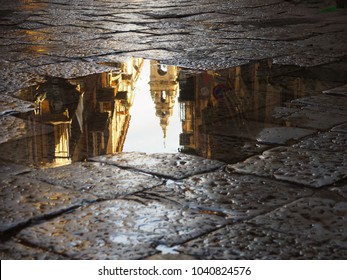 church tower in palermo reflecting in a puddle after the rain