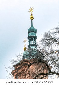 Church tower and upper structure in sharp focus, highlighting architectural details and vertical design. A clean composition emphasizing the top section of a religious building against the sky.