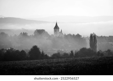 A Church Towering Over the Autumn Mist. Black and white photo - Powered by Shutterstock