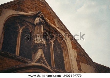 Church window with statue of a winged angel in front