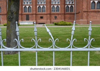 the church yard is surrounded by modest metal fence