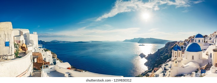 Churches in Oia, Santorini island in Greece, on a sunny day. Panorama view.