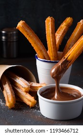 Churro With Sugar Powder And Cinnamon In Melted Chocolate Dip