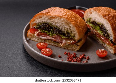 Ciabata with jamon or prosciutto, tomatoes, cheese and lettuce with salt, spices and herbs - Powered by Shutterstock