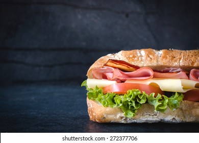 Ciabatta Bread Stuffed With Cheese,meat And Vegetables On Dark Background,selective Focus And Blank Space