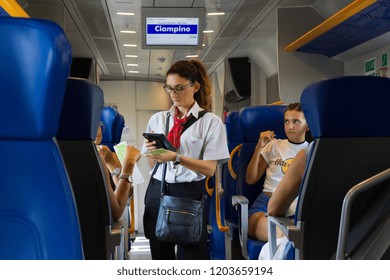 Ciampino, Italy. 2018/8/21. A Female Train Conductor Checking Tickets On Board A Train Heading From The Ciampino Airport Near Rome.