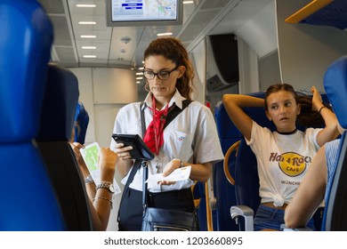 Ciampino, Italy. 2018/8/21. A Female Train Conductor Checking Tickets On Board A Train Heading From The Ciampino Airport Near Rome.