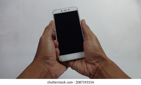 Cibinong, 7 December 2021, Two Hands Of Someone Holding A Cellphone With A Dark Screen