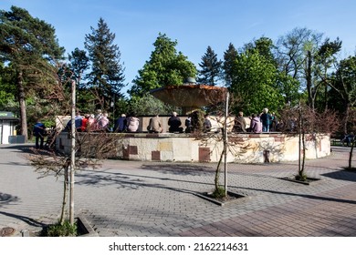 Ciechocinek, Poland - May 08.2022: Ciechocinek - a health resort (spa) town in Poland. Patients sitting around the city fountain built above the well breathe air saturated with brine.
