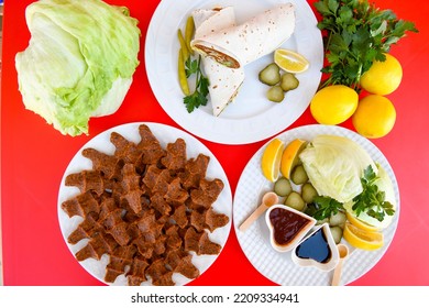 Cig Kofte (raw Meatball) With Lettuce, Tomato, Pickle And Lemon, Hot Chee Kofta. Turkish Local Raw Food Concept.Table Scene Of Assorted Take Out Or Delivery Foods. Top View Of Assorted Turkish Food.