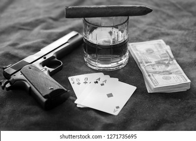 Cigar. Black and White. Hand Gun, Poker Hand, Cash, Whiskey and Cigar on Leather table. 