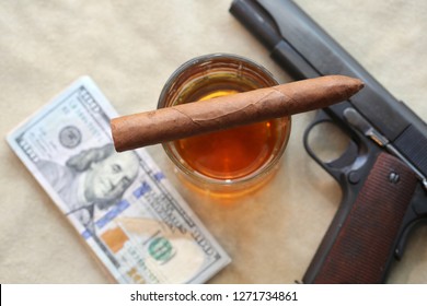 Cigar. Cuban Cigar, Whiskey, Cash, Poker Hand, and a Hand Gun on a Leather background. 