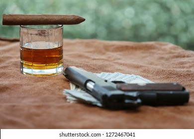 Cigar. Cuban Cigar, Whiskey, Cash, Poker Hand, and a Hand Gun on a Leather background. 