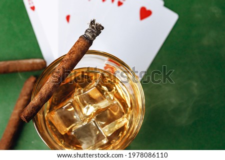 Cigar and playing cards on casino table