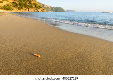 Cigarette bud thrown away at a clean sandy beach shore