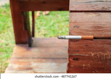 Cigarette burn selective focus on a wooden table  at hazard Health