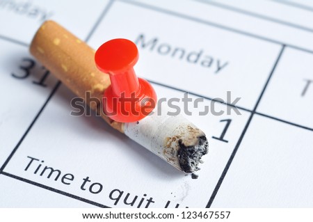 Cigarette butt impaled on calendar Foto stock © 