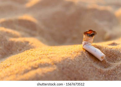 Cigarette butt on the beach. Ocean pollution concept