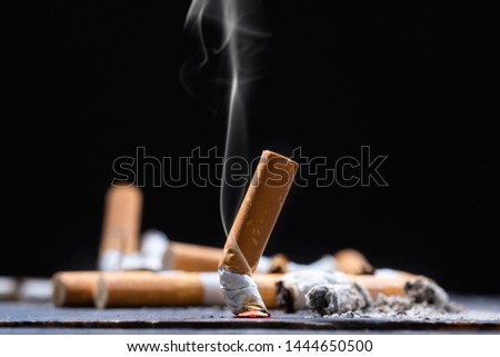 Cigarette butt on wooden table with black background