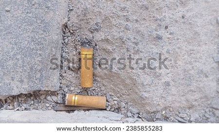 a cigarette butt that had been discarded on the ground and lying in soil