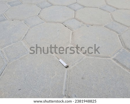 a cigarette butt thrown on the pavement