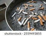 cigarette butts in an ashtray, many cigarettes debris after smoking