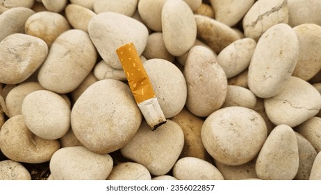 Cigarette butts on a pile of white stones. Health concept. White stone background (texture). Pile of white stones forming an abstract pattern. Used as background or copyscape.