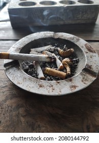 A Cigarette In A Full Ashtray