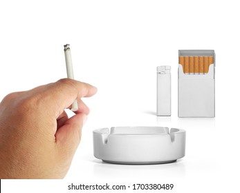 A cigarette in a hand, Cigarette pack, ashtray, and lighters isolated on white background