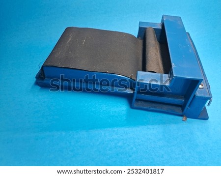 Cigarette rolling tool isolated on blue background, used for making cigarettes or rolling cigarettes. 