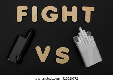 Cigarettes Against Vape. Electronic Cigarette Over A Dark Background. E-cigarette For Vaping. Popular Devices Of The Year - Modern Vaping Device. Stop Smoking,start Vaping Vape.