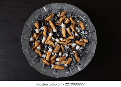 Cigarrillos en un cenicero, cenizas, muchos cigarrillos ahumados. Una fuerte pasión por fumar. Perjudicial para la salud. Fumar puede ser perjudicial para su salud. Es una pena para el medio ambiente. Problemas de salud.