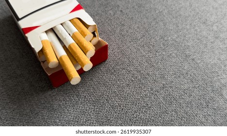 Cigarettes in a pack. Yellow filter. Harm to health. Bad habit. A pack of cigarettes on the table. open pack of cigarettes.