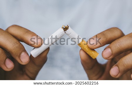Cigarette.World No Tobacco Day Concept.Stop smoking cigarettes concept. Closeup woman holding broken cigarette in hands.
