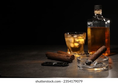 Cigars, ashtray, whiskey and cutter on grey table against black background. Space for text - Powered by Shutterstock