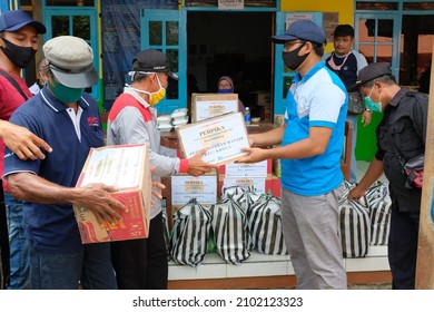 Cilacap, Indonesia - October 2020 : the process of handing over aid from the Karangtaruna community to representatives of flood victims in Gentasari village.