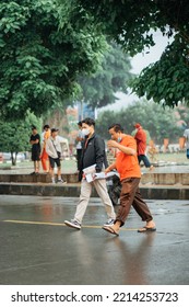 Cilacap, Indonesia, September 2022 - Two People Walking Fast When It Starts To Rain In A City