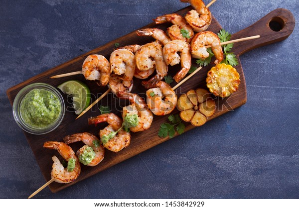 Cilantro lime grilled\
shrimps. Shrimps on skewers with garlic butter sauce. View from\
above, top studio shot
