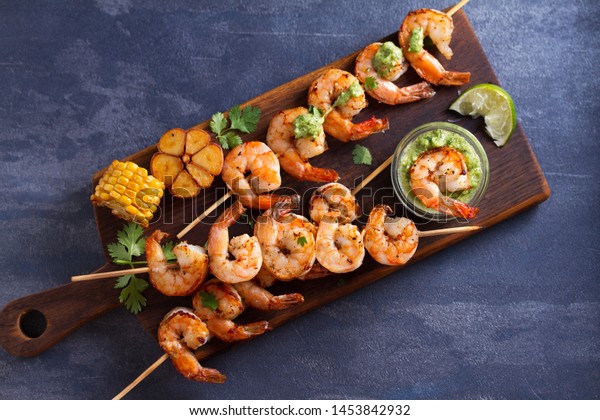 Cilantro lime grilled\
shrimps. Shrimps on skewers with garlic butter sauce. View from\
above, top studio shot